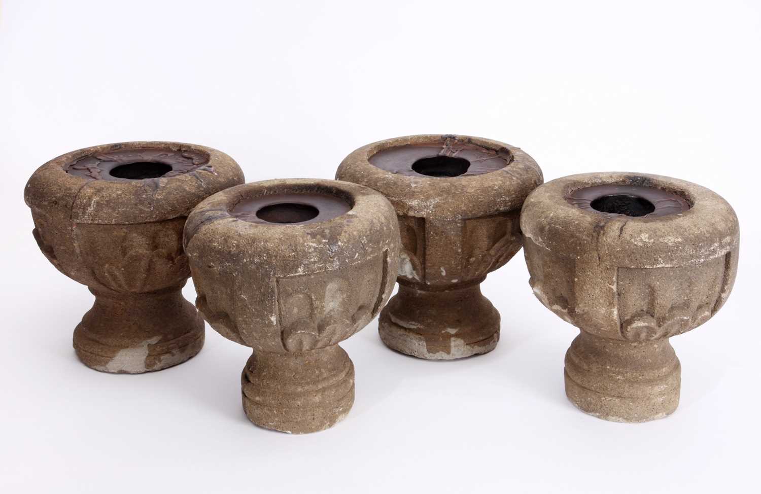 Lot 83 - A set of four cast cement candle holders